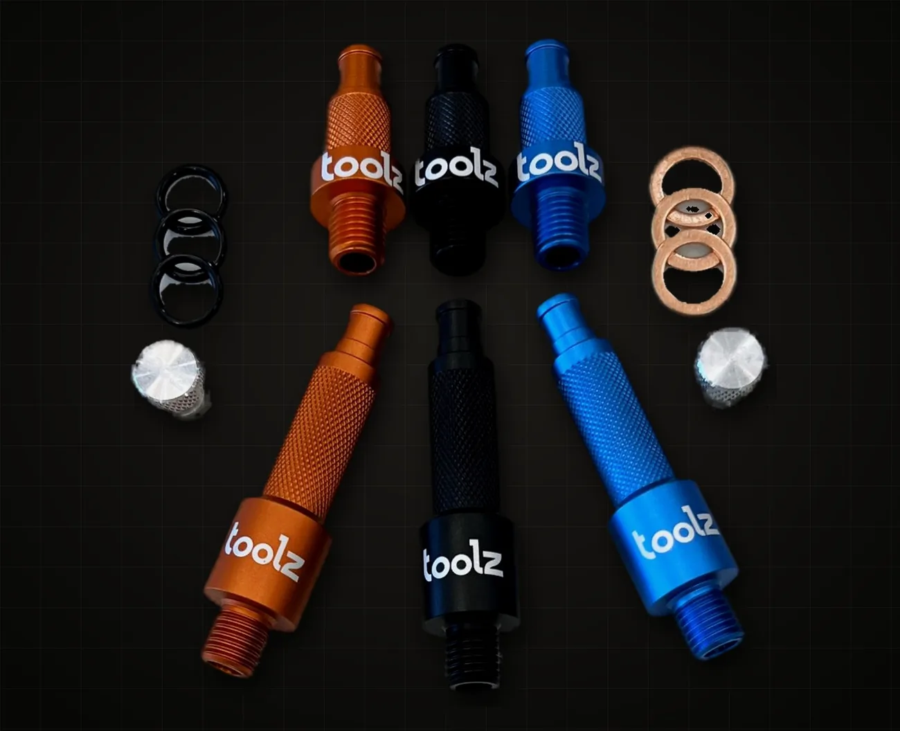 Orange, black and blue tools laid out with O rings, copper washers and bungs